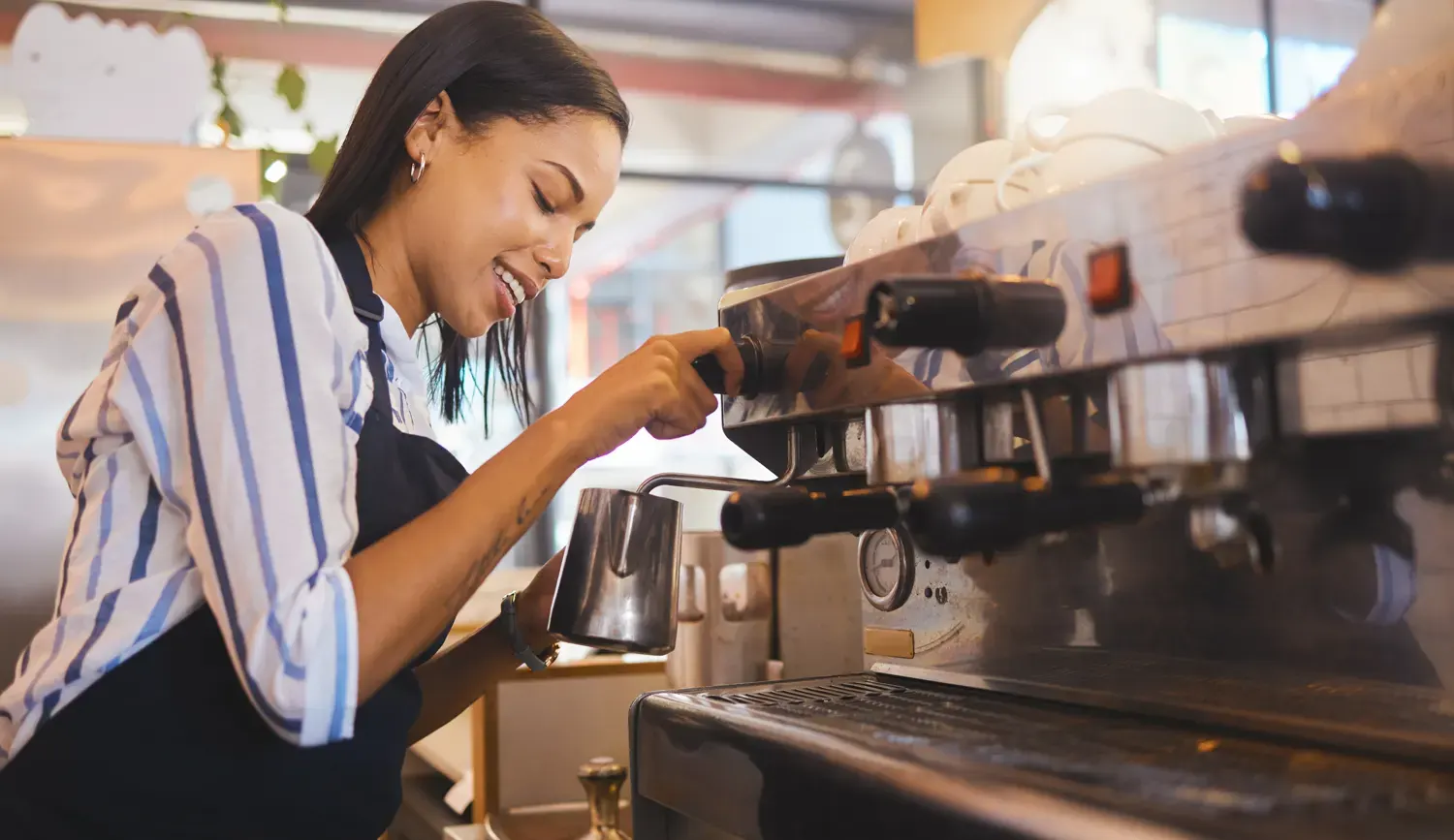 Barista bereitet Milchschaum mit der Dampflanze zu